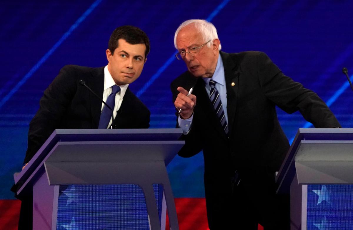 South Bend Mayor Pete Buttigieg talks with Senator Bernie Sanders during the 2020 Democratic U.S. presidential debate in Houston