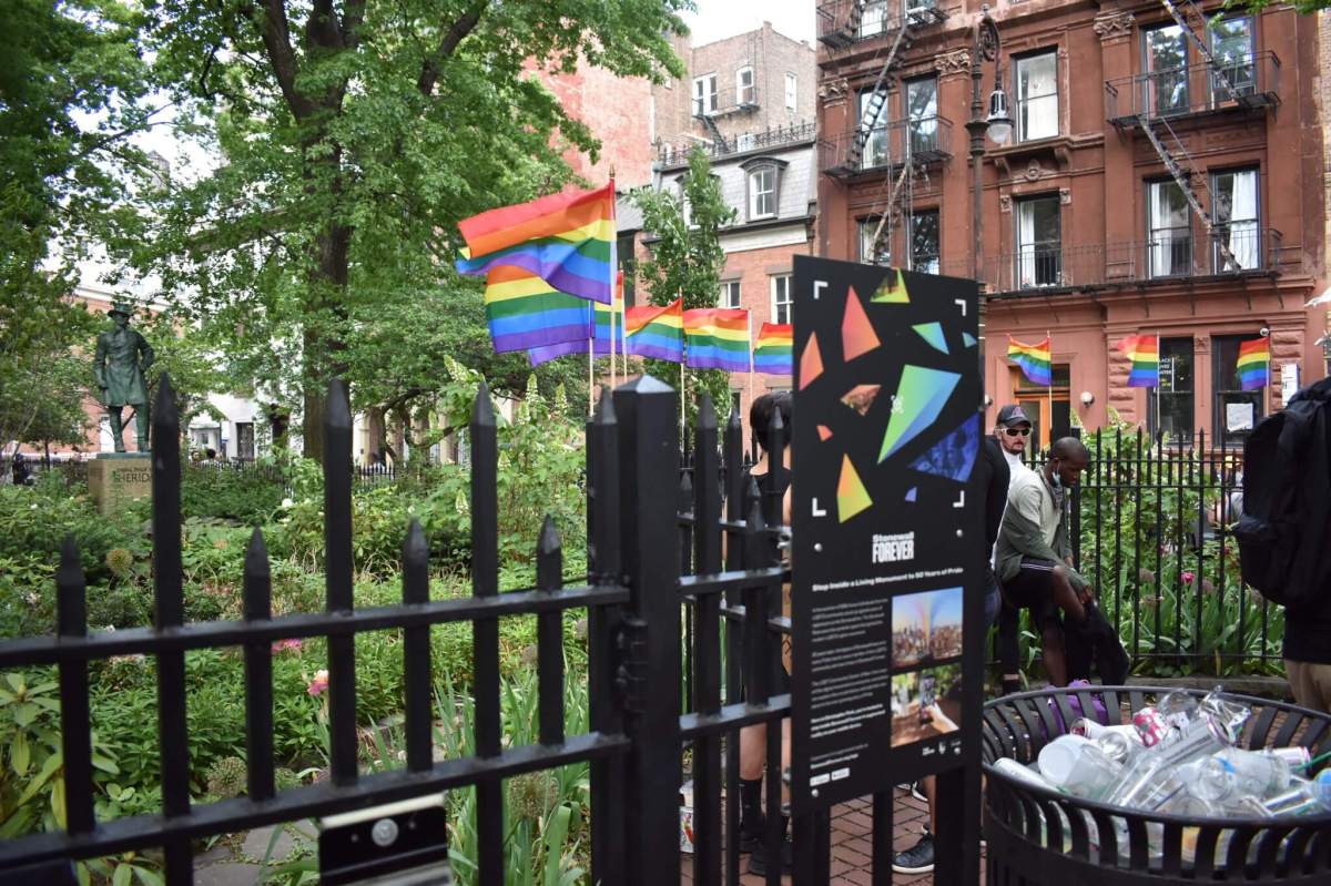 A collection of Rainbow Flags blow in the wind at Christopher Park.