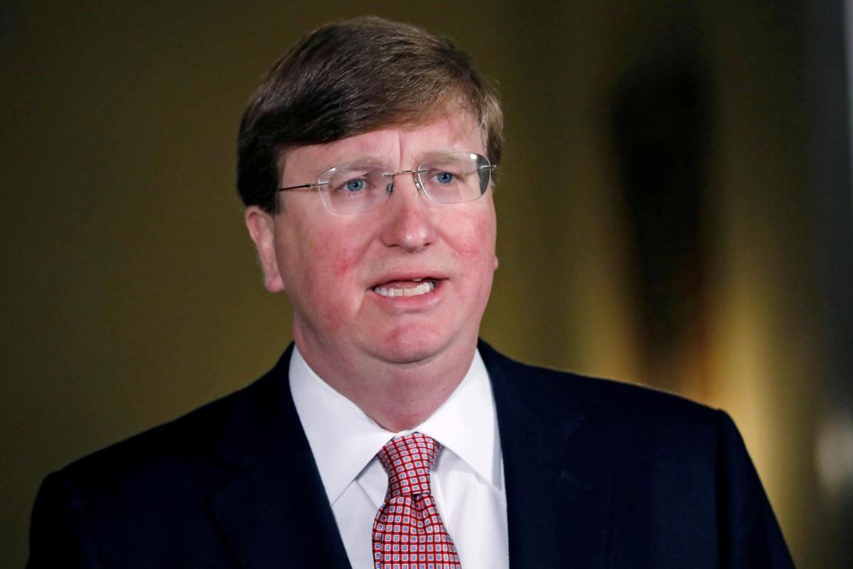 Mississippi Gov. Tate Reeves signs the bill retiring the last state flag in the United States with the Confederate battle emblem, during a ceremony at the Governor’s Mansion in Jackson