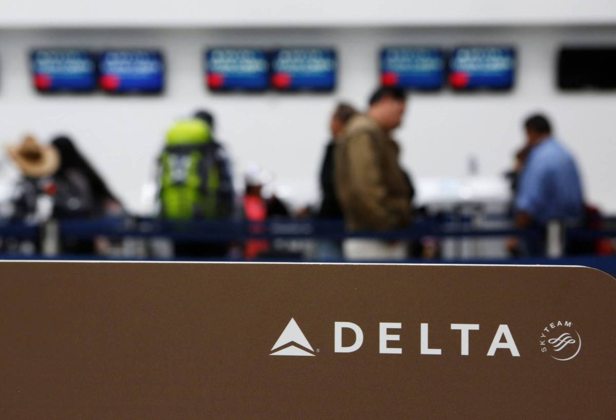 Passengers check in at a counter of Delta Air Lines in Mexico City