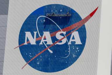 FILE PHOTO: Workers pressure wash the logo of NASA on the Vehicle Assembly Building, in Cape Canaveral