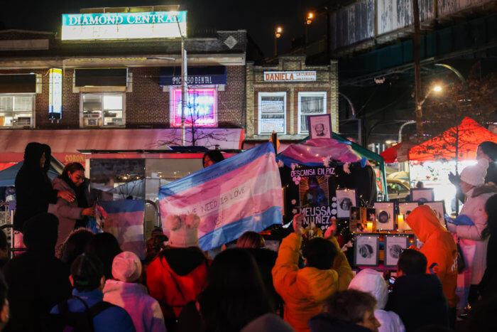 A crowd gathers around the Corona Plaza vigil.