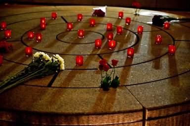 Candles and flowers rest at the NYC AIDS Memorial.