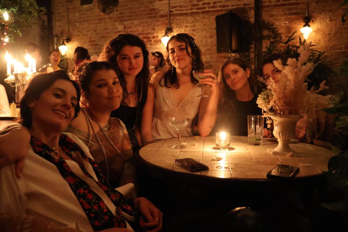 A group of party-goers share drinks at their table.