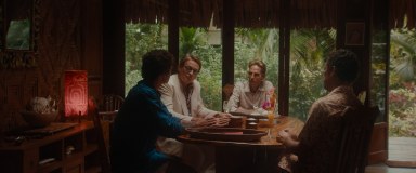 People sit around a table during a scene in “Pacifiction."