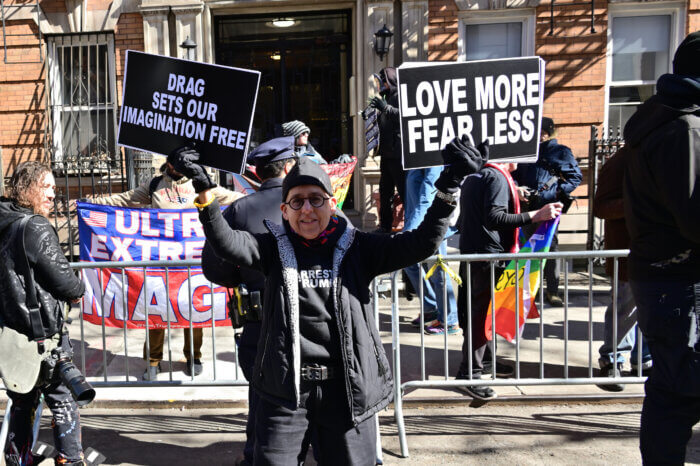 Affirming messages of support drown out anti-LGBTQ demonstrators in the background.