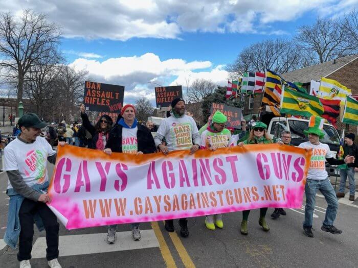 The Gays Against Guns crew marches behind their banner.