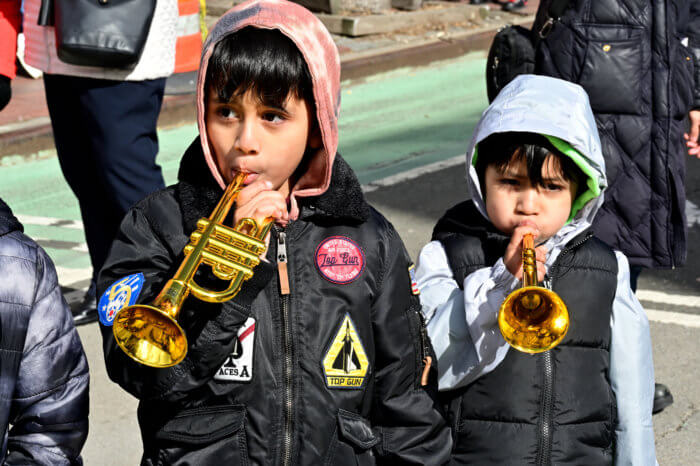 The marching band gets a helping hand from young spectators.