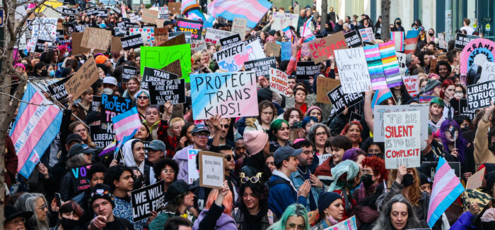 Creative and colorful signs wave above the crowd.