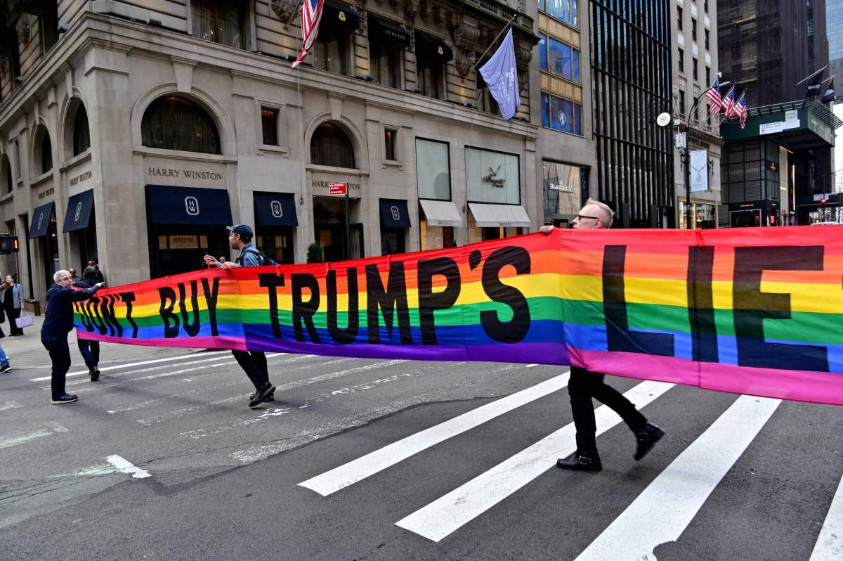 Gilbert Baker's "DON'T BUY TRUMP'S LIES" banner crosses the street.