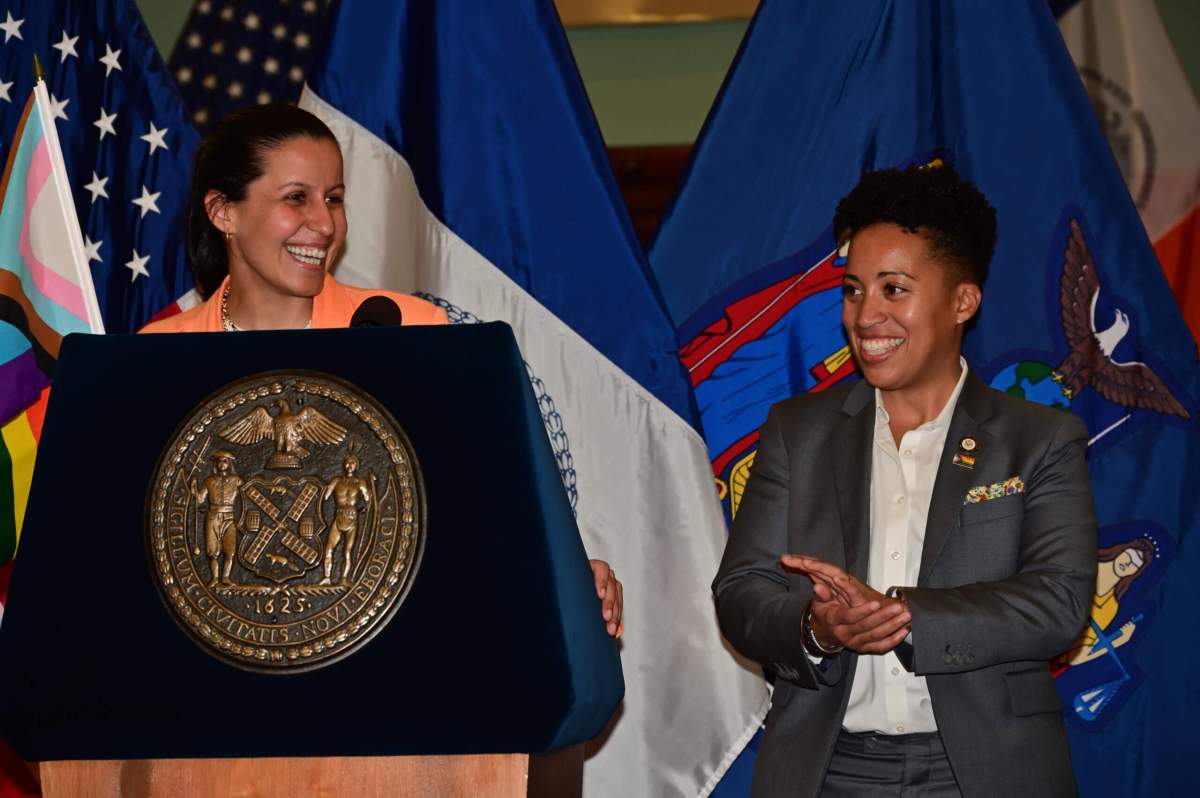 The event's hosts and co-chairs of the LGBTQIA+ Caucus, Tiffany Caban and Crystal Hudson, stand at the podium.