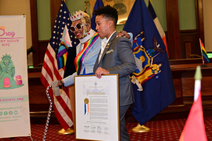 Hudson escorts honoree Rev. Goddess Magora Kennedy back to her seat.