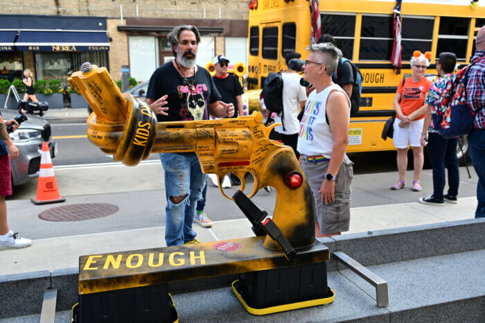 Manuel Oliver stands near a sculpture bringing awareness to gun violence.