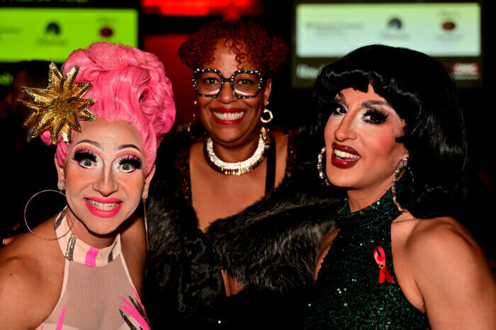 Cacophony Daniels (left) and Jackie Cox (right) pose with Lambda Literary executive director Samiya Bashir for Banned Books Week.